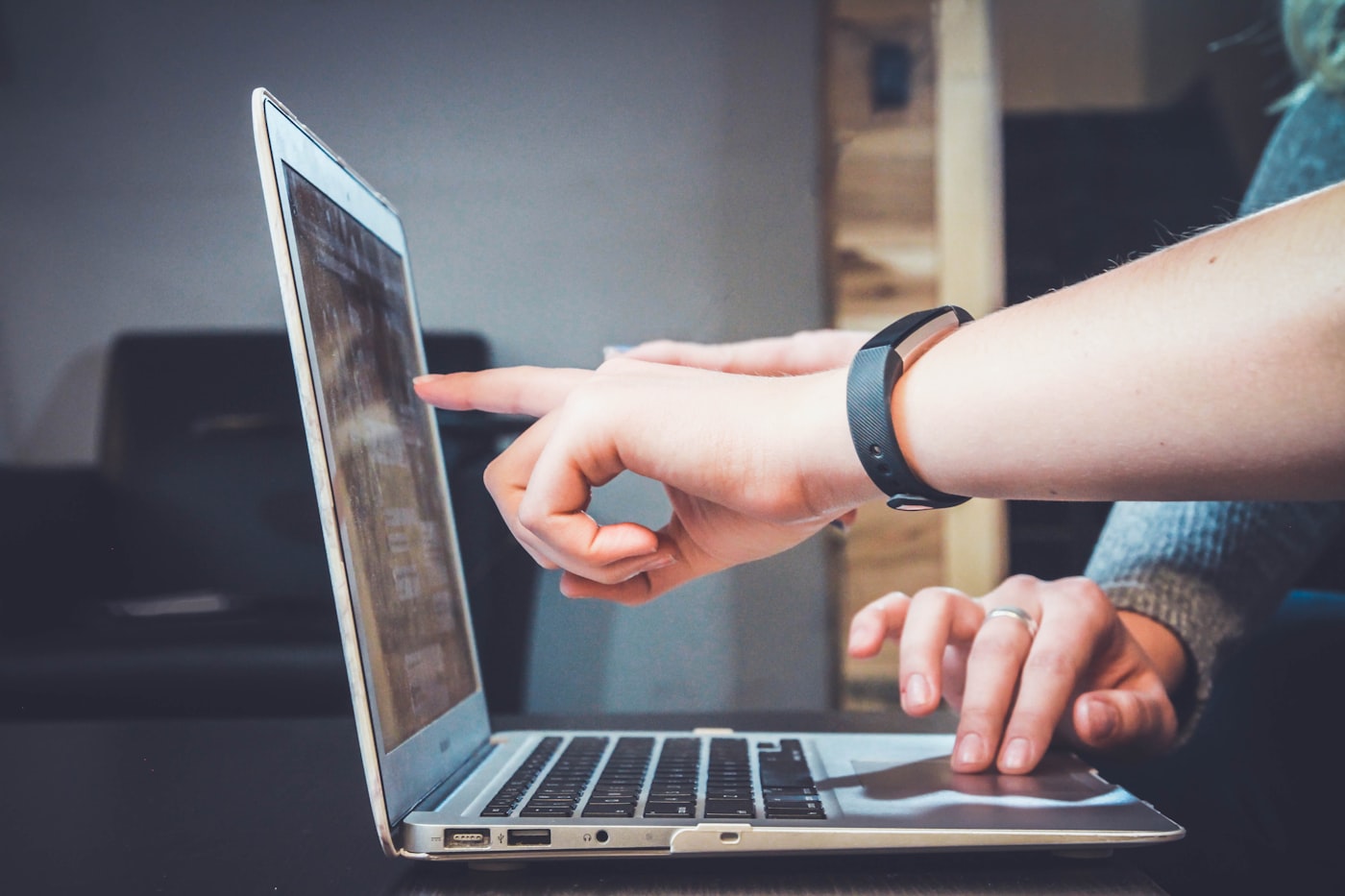 Hands pointing at a laptop screen while working
