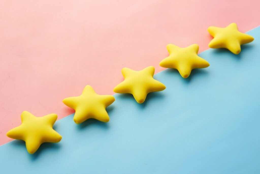 Five yellow stars in a row on a pink and blue background